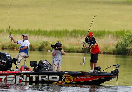 Kevin VanDam swings aboard a small fish as a local camera crew films the action.