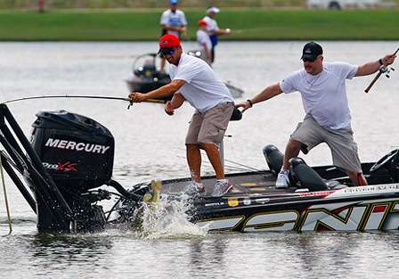 A fish makes an acrobatic jump as Edwin Evers and Tim Murray scramble to move about the boat.
