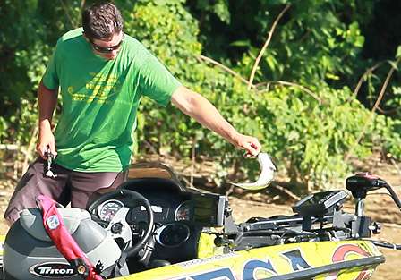 After removing his bait, Derek Remitz tosses a bass back into the river.