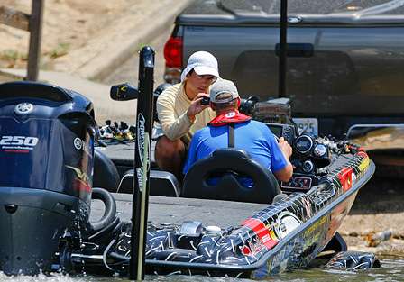 Russ Lane puts his boat on the trailer to move to another ramp, while Rob Russow gets an update on his practice on BASSCam. 