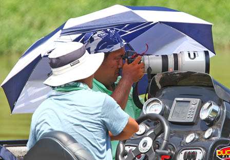 Seigo Siato shoots the action from under an umbrella on Day One.