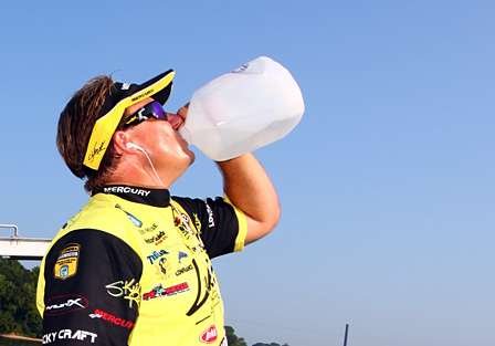 With a forecasted heat index of 110F, Skeet Reese hydrates. 