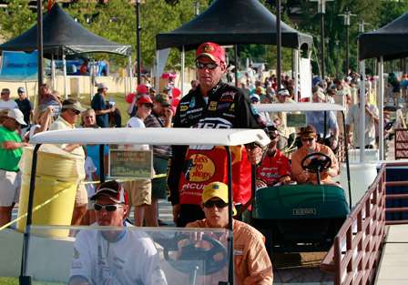 Elite Series pro Kevin VanDam is taken by cart to the back of the stage to the soak tanks.