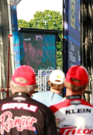 Veteran Elite pros Tommy Biffle (right) and Gary Klein watch the weigh in on the Jumbotron from behind the stage.