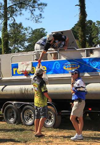 Derek Remitz hands off his fish to Tournament Manager Jon Stewart who is taking care of the fish so they can be released alive into Lake Seminole.