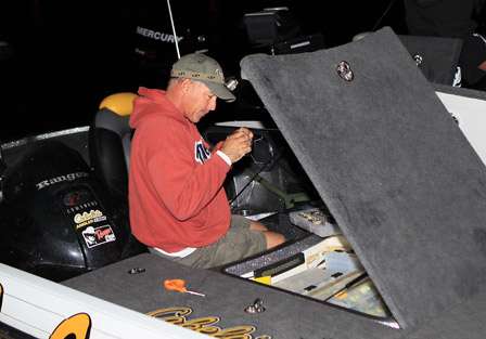 Clark Wendlandt tries his best to thread his line through the eye of the hook in near-total darkness.