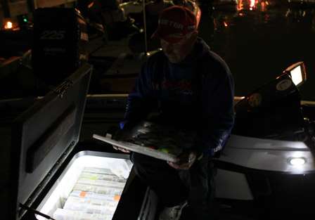 Dave Mansue is illuminated by the lights in his tackle storage as he looks through a tray of baits.