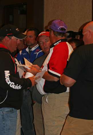 After the random boat draw, boaters meet with their partners to discuss plans for the morning of fishing.