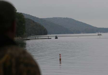 Two boats make a few last-minute casts near the launch as spectators look on.