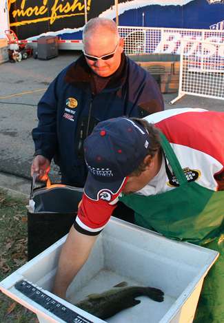Tournament officials check non-boater Dennis McGouirk's fish before he weighs in.