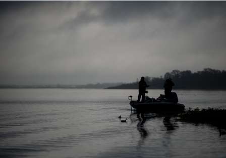 Garry Rogers fishes silouetted against the early morning sky as cloud cover dominates the Kissimmee area.
