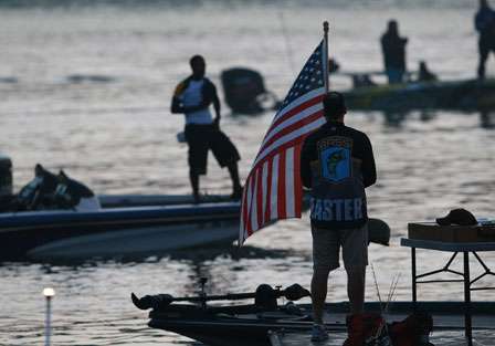 Anglers honor the flag as the traditional playing of the national anthem is carries out on Day One.