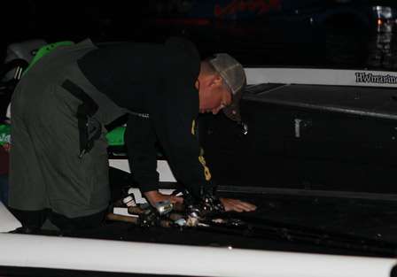 Kevin Ledoux retrieves his rods from his boat locker as he prepares for the first day of competition.
