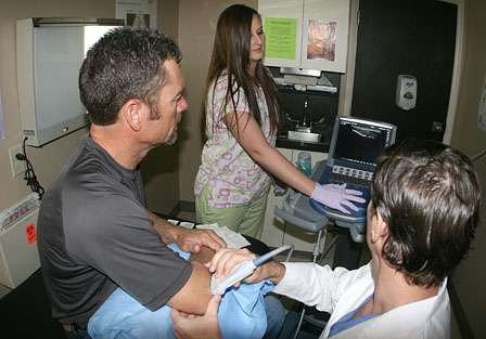Sloan uses an ultrasound machine to better diagnose the injured area.