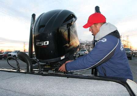 Greg Vinson reaches toward his motor to put safety straps on after a day of fishing.