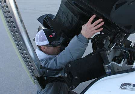 John Crews crouches down to remove his engine supports on Saturday morning.
