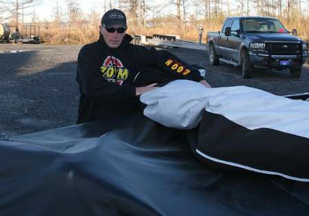 Andy Montgomery rolls up the cover of his boat before the second day of practice for the 2011 Bassmaster Classic.