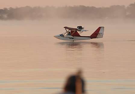 A seaplane gently touches down in the morning sun.