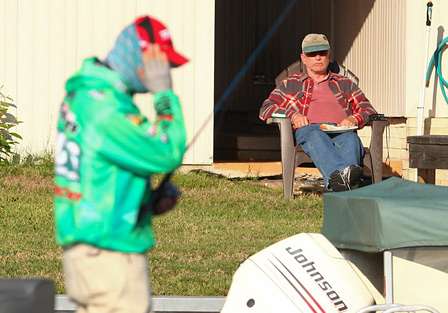 A spectator eats breakfast while watching Grigsby fish. 