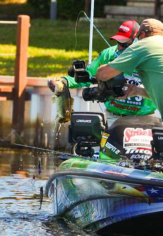 Grigsby hauls the bass aboard as Rick Mason captures the action for Bassmaster television. 