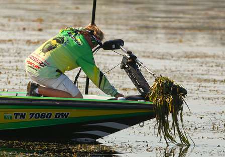 J. Todd Tucker raises his trolling motor to free it from the thick grass. 