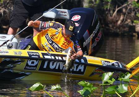 Scroggins grips the bass and puts another keeper in the boat. 