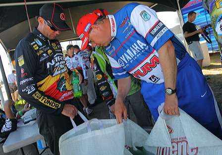Alton Jones takes a peek at Kevin VanDam's catch behind the scenes at the Day Three weigh-in.