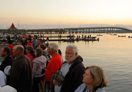 Spectators and anglers stand for the national anthem. 