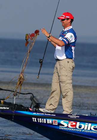 Faircloth reels in some of the vegetation that's been holding bass. 