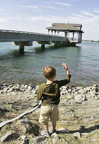 Chase DeHart throws rocks into Lake Norman waiting for his dad to weigh in.