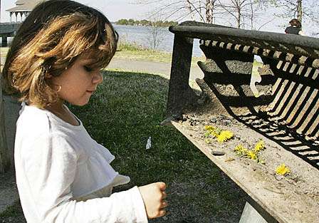 Not much into fish being weighed, Alexis Martinez, 4, tosses some dandelions on the grill.