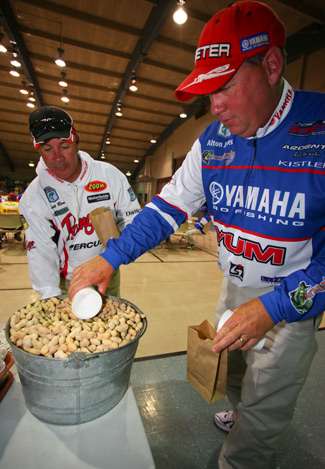 Scott Rook and Alton Jones scoop up a bag of peanuts to snack on during the anglers meeting. 
