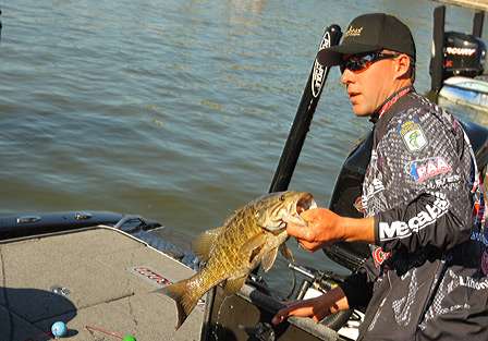 Aaron Martens puts a smallmouth in his weigh-in bag.