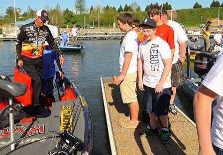 A group of young fans hang around Kevin VanDam's boat.