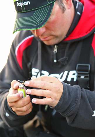 Fred Roumbanis uses a lighter to get a hook ready for another day on the water.