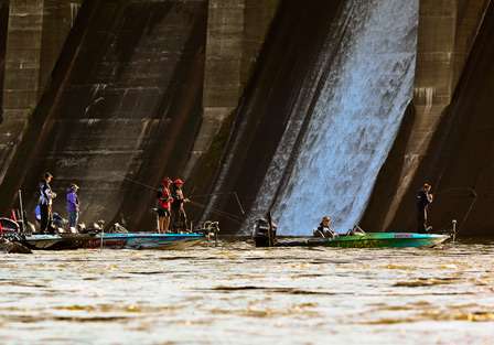 Anglers crowd together to fish below the dam. 