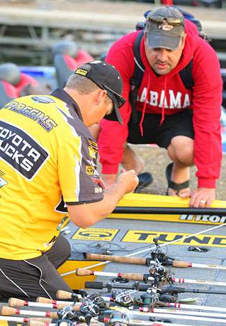 Mark Zona peeks into the boat of Terry Scroggins, who has a large assortment of rods on his front deck.