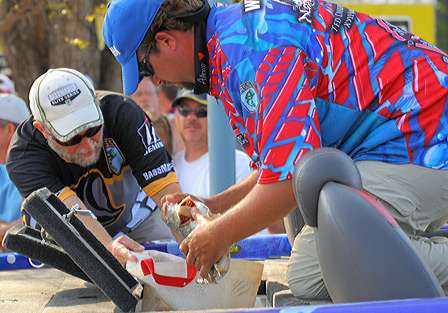 Chuck Harbin helps Elite Series rookie Nate Wellman bag his fish.