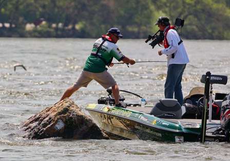 Hite fights to keep his boat out of the boulders as he fights a fish. 