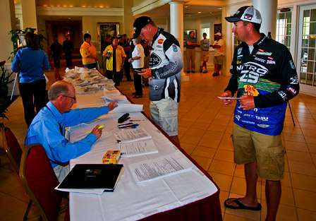 Tournament Director Trip Weldon checks the pros' fishing licenses prior to registration.
