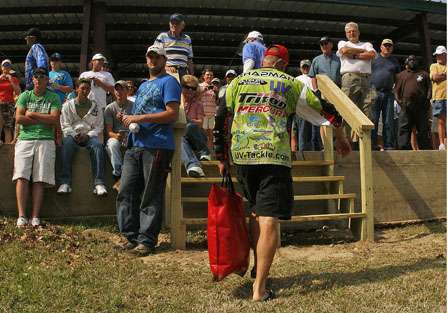 Brent Chapman totes his sack to the weigh-in, while a line of spectators watch the anglers approach.