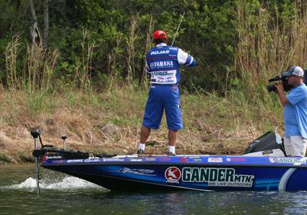 A large bass splashes by the side of the boat as Rojas prepares to swing the fish in.