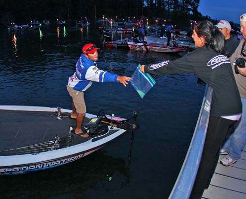 <p>
	Brandon Palaniuk reaches for a bag of Catch-and-Release formula.</p>
