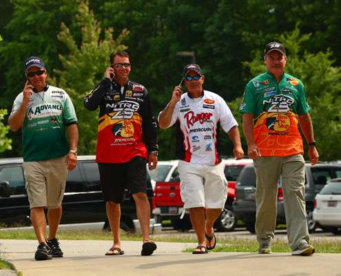 <p> 	Davy Hite, Kevin VanDam and Scott Rook talk on their cell phones as they walk with Dennis Tietje to the meeting.</p> 