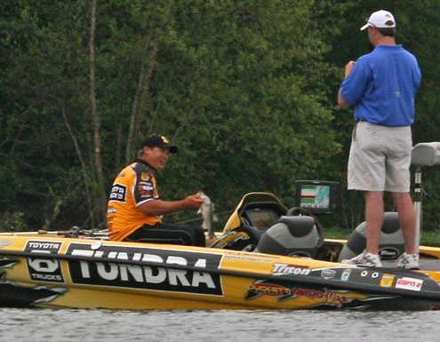 <p>
	Scroggins holds up a good quality fish as his Marshal takes a picture.</p>
