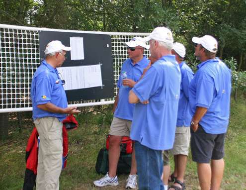 <p>
	A group of Marshals stand around the pairings board to see who they will be riding with on Day Three.</p>
