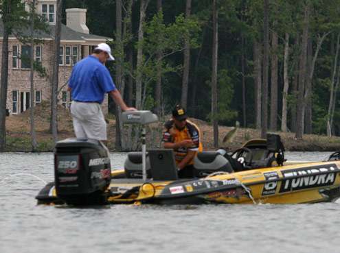 <p>
	Moving to the back of the boat, Terry Scroggins tosses back the smallest bass after culling.</p>
