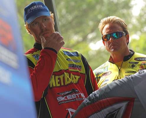 <p>
	Greg Vinson and Skeet Reese watch from the weigh-in tanks as another angler crosses the stage.</p>
