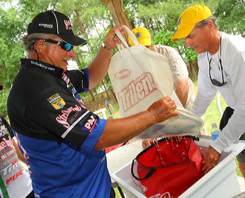 <p>
	Denny Brauer pulls out his mesh bag of bass before getting in line to weigh-in.</p>
