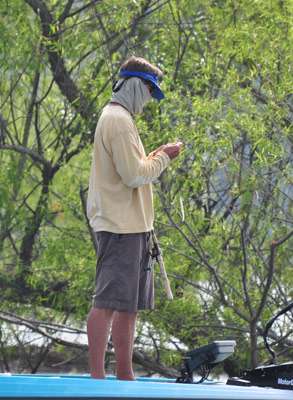 <p>
	Bernie Schultz protects himself from the sun as he fishes down the bank.</p>
